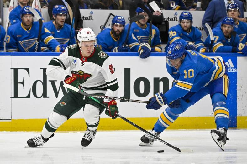 Dec 31, 2022; St. Louis, Missouri, USA;  Minnesota Wild left wing Kirill Kaprizov (97) controls the puck as St. Louis Blues center Brayden Schenn (10) defends during the first period at Enterprise Center. Mandatory Credit: Jeff Curry-USA TODAY Sports