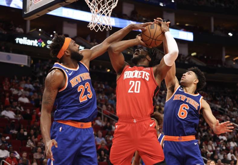 Dec 31, 2022; Houston, Texas, USA; Houston Rockets forward Bruno Fernando (20) is fouled by New York Knicks guard Quentin Grimes (6) as center Mitchell Robinson (23) tries to block the shot also in the second quarter at Toyota Center. Mandatory Credit: Thomas Shea-USA TODAY Sports