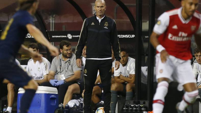 Jul 23, 2019; Landover, MD, USA; Real Madrid head coach Zinedine Zidane (M) looks on from the bench against Arsenal in the second half of a match in the International Champions Cup soccer series at FedEx Field. Real Madrid won 2-2 (3-2 pen.). Mandatory Credit: Geoff Burke-USA TODAY Sports