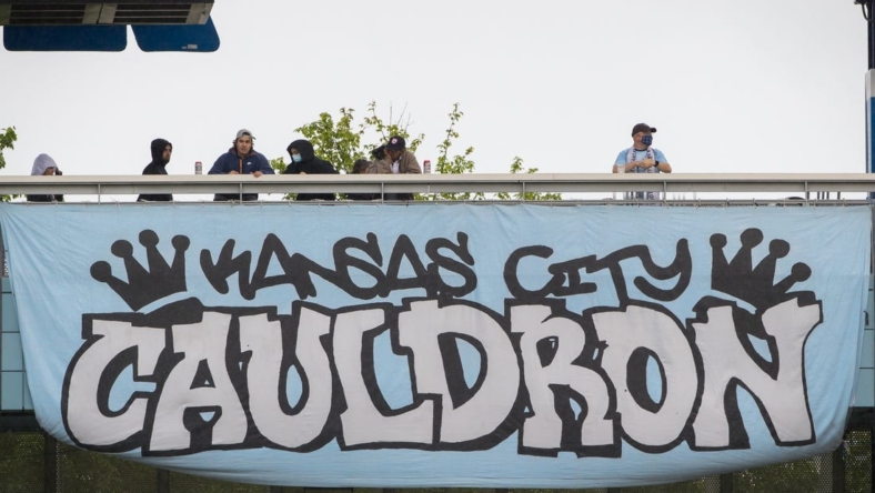 May 16, 2021; Kansas City, Kansas, USA;  fans stand on the balcony over one of the club banners during the game between the Sporting Kansas City and the Vancouver Whitecaps at Children's Mercy Park. Mandatory Credit: William Purnell-USA TODAY Sports