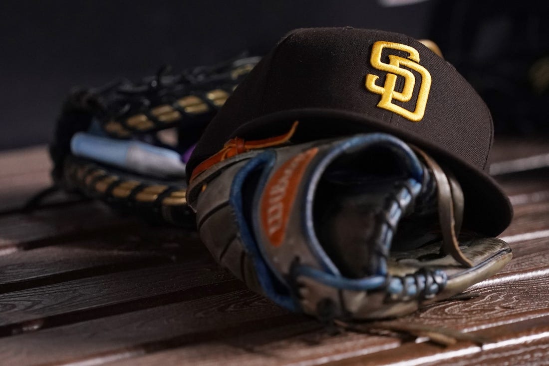 Jul 23, 2021; Miami, Florida, USA; A general view of a San Diego Padres hat and glove in the dugout prior to the game between the Miami Marlins and the San Diego Padres at loanDepot park. Mandatory Credit: Jasen Vinlove-USA TODAY Sports