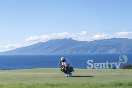 January 8, 2022; Maui, Hawaii, USA; Jon Rahm lines up his putt on the 10th hole during the third round of the Sentry Tournament of Champions golf tournament at Kapalua Resort - The Plantation Course. Mandatory Credit: Kyle Terada-USA TODAY Sports