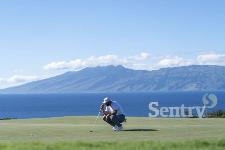January 8, 2022; Maui, Hawaii, USA; Jon Rahm lines up his putt on the 10th hole during the third round of the Sentry Tournament of Champions golf tournament at Kapalua Resort - The Plantation Course. Mandatory Credit: Kyle Terada-USA TODAY Sports