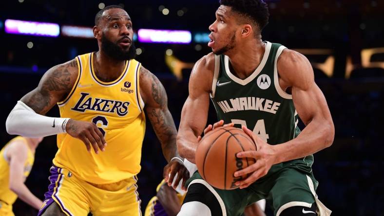 Feb 8, 2022; Los Angeles, California, USA; Milwaukee Bucks forward Giannis Antetokounmpo (34) moves the ball against Los Angeles Lakers forward LeBron James (6) during the second half at Crypto.com Arena. Mandatory Credit: Gary A. Vasquez-USA TODAY Sports