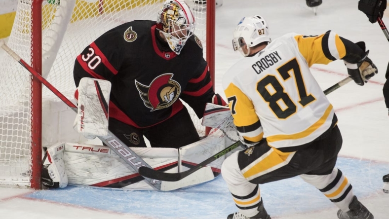 Feb 10, 2022; Ottawa, Ontario, CAN; Ottawa Senators goalie Matt Murray (30) makes a save in front of Pittsburgh Penguins center Sidney Crosby (87) in the third period at the Canadian Tire Centre. Mandatory Credit: Marc DesRosiers-USA TODAY Sports