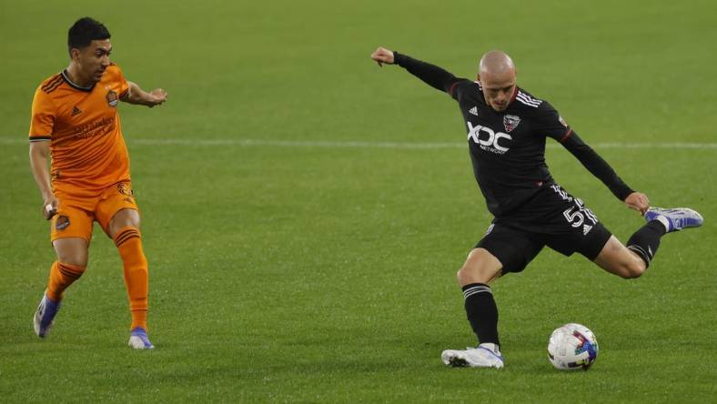 May 7, 2022; Washington, District of Columbia, USA; D.C. United defender Brad Smith (5) crosses the ball as Houston Dynamo midfielder Memo Rodr guez (8) defends in the second half at Audi Field. Mandatory Credit: Geoff Burke-USA TODAY Sports