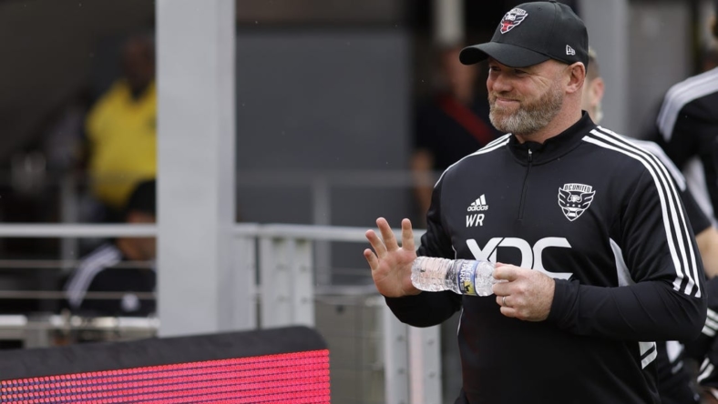 Jul 31, 2022; Washington, District of Columbia, USA; D.C. United head coach Wayne Rooney waves to fans while walking onto the pitch for his first game as head coach against Orlando City SC at Audi Field. Mandatory Credit: Geoff Burke-USA TODAY Sports