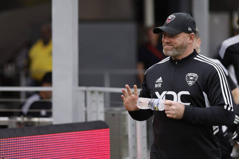 Jul 31, 2022; Washington, District of Columbia, USA; D.C. United head coach Wayne Rooney waves to fans while walking onto the pitch for his first game as head coach against Orlando City SC at Audi Field. Mandatory Credit: Geoff Burke-USA TODAY Sports