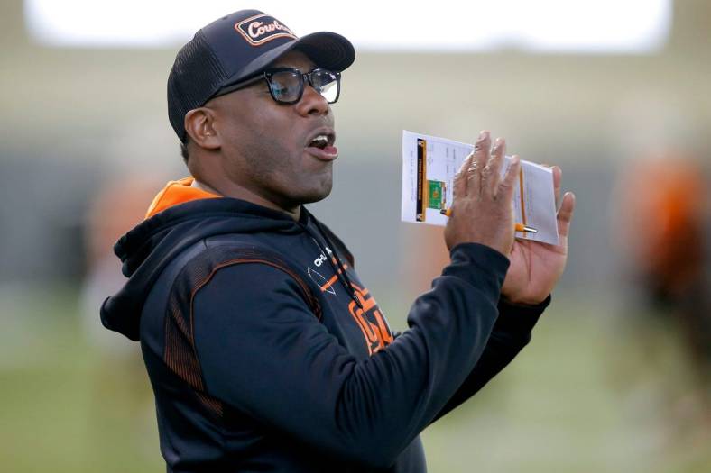 OSU defensive coordinator Derek Mason shouts instructions to his players on March 22.

cover small