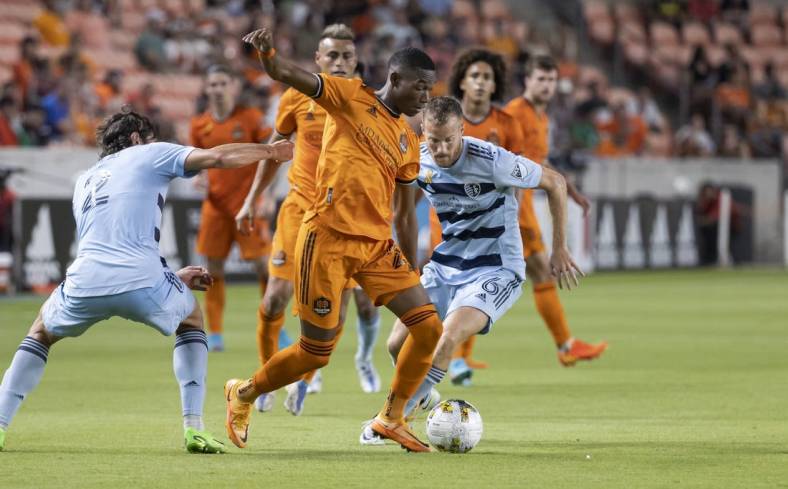 Sep 10, 2022; Houston, Texas, USA; Houston Dynamo FC forward Nelson Quinones (21) and Sporting Kansas City midfielder Uri Rosell (6) battle for the ball during the second half at PNC Stadium. Mandatory Credit: Troy Taormina-USA TODAY Sports