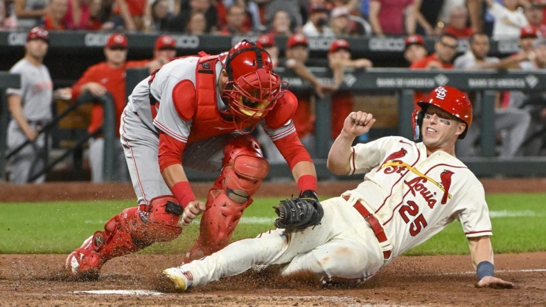 Sep 17, 2022; St. Louis, Missouri, USA;  St. Louis Cardinals left fielder Corey Dickerson (25) is tagged out at home by Cincinnati Reds catcher Austin Romine (28) during the tenth inning at Busch Stadium. Mandatory Credit: Jeff Curry-USA TODAY Sports