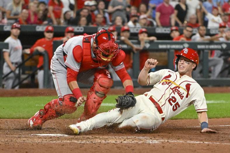 Sep 17, 2022; St. Louis, Missouri, USA;  St. Louis Cardinals left fielder Corey Dickerson (25) is tagged out at home by Cincinnati Reds catcher Austin Romine (28) during the tenth inning at Busch Stadium. Mandatory Credit: Jeff Curry-USA TODAY Sports