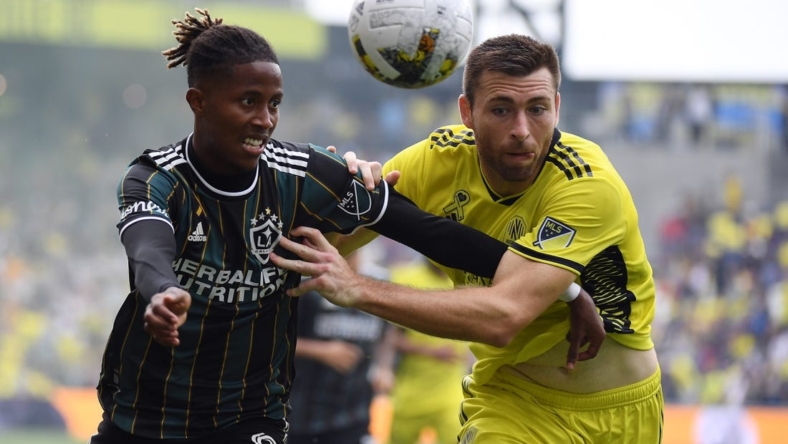 Sep 10, 2022; Nashville, Tennessee, USA; Los Angeles Galaxy forward Kevin Cabral (9) and Nashville SC defender Dave Romney (4) battle for a loose ball during the first half at Geodis Park. Mandatory Credit: Christopher Hanewinckel-USA TODAY Sports