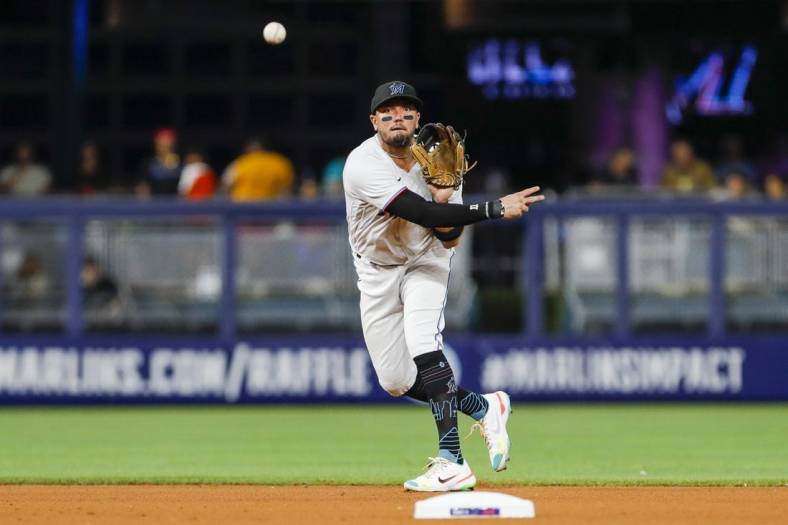 Sep 21, 2022; Miami, Florida, USA; Miami Marlins shortstop Miguel Rojas (11) throws to first base to retire Chicago Cubs second baseman David Bote (not pictured) during the fourth inning at loanDepot Park. Mandatory Credit: Sam Navarro-USA TODAY Sports