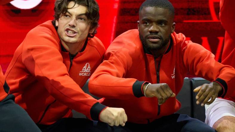 Sep 23, 2022; London, United Kingdom;  Team World players, Taylor Fritz (USA) and Frances Tiafoe (USA),  show their support in the Laver Cup tennis match between Andy Murray (GBR) and Alex De Minaur (AUS) as Team World captain John McEnroe looks on.  Mandatory Credit: Peter van den Berg-USA TODAY Sports