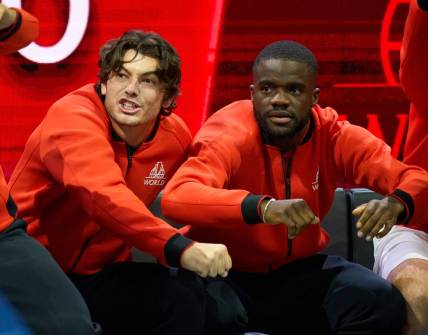Sep 23, 2022; London, United Kingdom;  Team World players, Taylor Fritz (USA) and Frances Tiafoe (USA),  show their support in the Laver Cup tennis match between Andy Murray (GBR) and Alex De Minaur (AUS) as Team World captain John McEnroe looks on.  Mandatory Credit: Peter van den Berg-USA TODAY Sports
