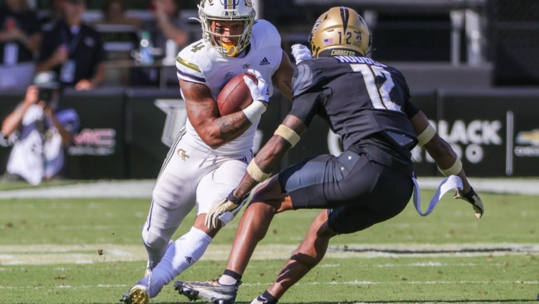 Sep 24, 2022; Orlando, Florida, USA; Georgia Tech Yellow Jackets running back Dontae Smith (4) runs the ball against UCF Knights defensive back Justin Hodges (12) during the first quarter at FBC Mortgage Stadium. Mandatory Credit: Mike Watters-USA TODAY Sports