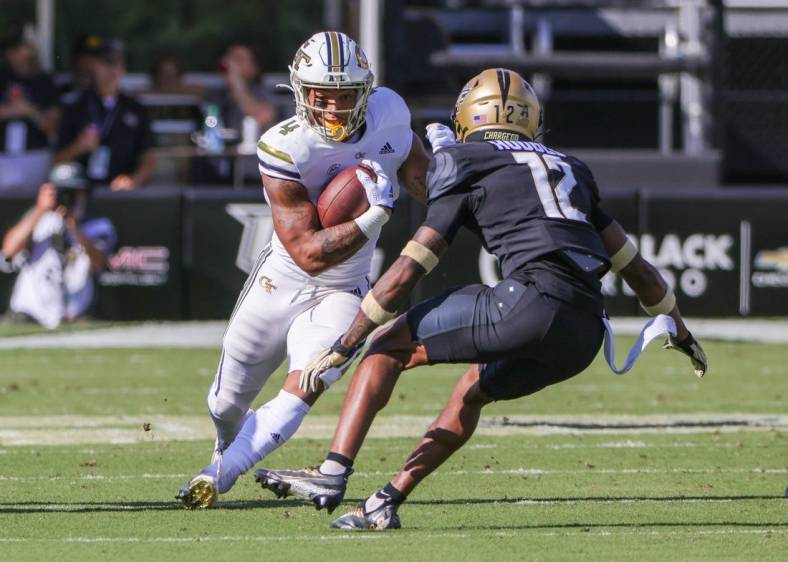 Sep 24, 2022; Orlando, Florida, USA; Georgia Tech Yellow Jackets running back Dontae Smith (4) runs the ball against UCF Knights defensive back Justin Hodges (12) during the first quarter at FBC Mortgage Stadium. Mandatory Credit: Mike Watters-USA TODAY Sports