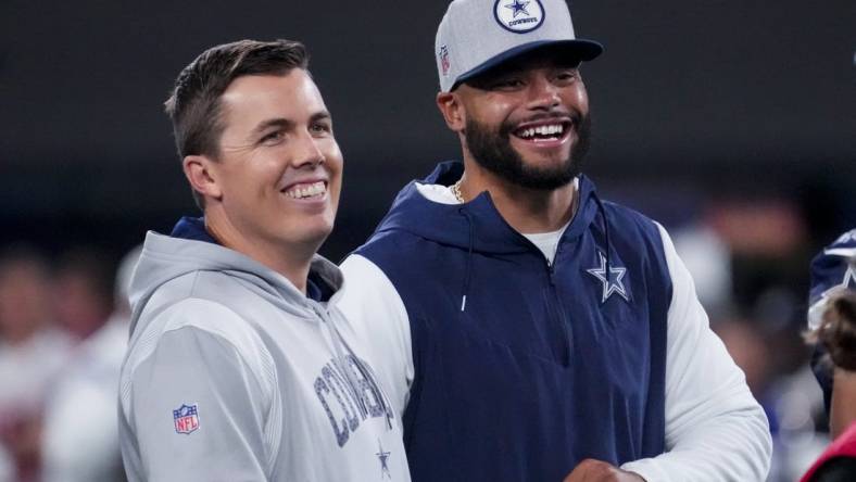 Sep 26, 2022; East Rutherford, New Jersey, USA;  Dallas Cowboys quarterback Dak Prescott (right) laughs with offensive coordinator Kellen Moore before the game against the New York Giants at MetLife Stadium. Mandatory Credit: Robert Deutsch-USA TODAY Sports