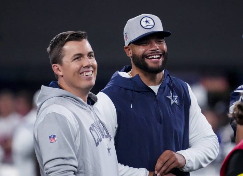 Sep 26, 2022; East Rutherford, New Jersey, USA;  Dallas Cowboys quarterback Dak Prescott (right) laughs with offensive coordinator Kellen Moore before the game against the New York Giants at MetLife Stadium. Mandatory Credit: Robert Deutsch-USA TODAY Sports