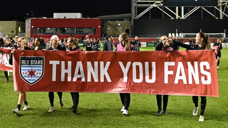 Oct 2, 2022; Bridgeview, Illinois, USA; Chicago Red Stars teammates hold up a sign to thank their fans after the game against Angel City FC at SeatGeek Stadium. Mandatory Credit: Daniel Bartel-USA TODAY Sports