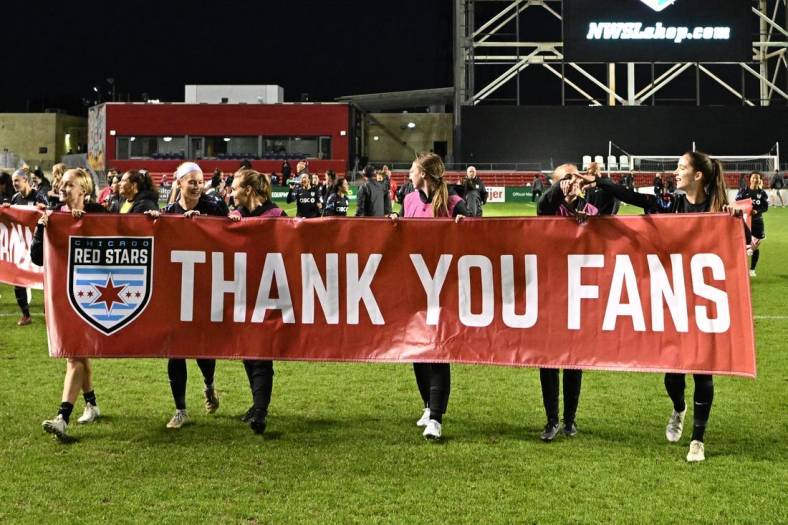 Oct 2, 2022; Bridgeview, Illinois, USA; Chicago Red Stars teammates hold up a sign to thank their fans after the game against Angel City FC at SeatGeek Stadium. Mandatory Credit: Daniel Bartel-USA TODAY Sports
