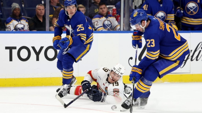 Oct 15, 2022; Buffalo, New York, USA;  Buffalo Sabres defenseman Owen Power (25) watches as Florida Panthers left wing Matthew Tkachuk (19) dives to clear the puck from Buffalo Sabres defenseman Mattias Samuelsson (23) during the third period at KeyBank Center. Mandatory Credit: Timothy T. Ludwig-USA TODAY Sports