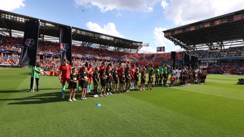 Oct 16, 2022; Houston, Texas, USA; Houston Dash and Kansas City Current line up with the Mastercard kids before the game at PNC Stadium. Mandatory Credit: Troy Taormina-USA TODAY Sports