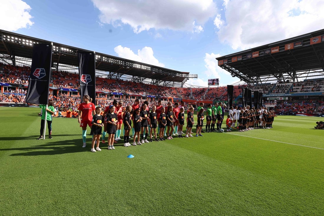Oct 16, 2022; Houston, Texas, USA; Houston Dash and Kansas City Current line up with the Mastercard kids before the game at PNC Stadium. Mandatory Credit: Troy Taormina-USA TODAY Sports