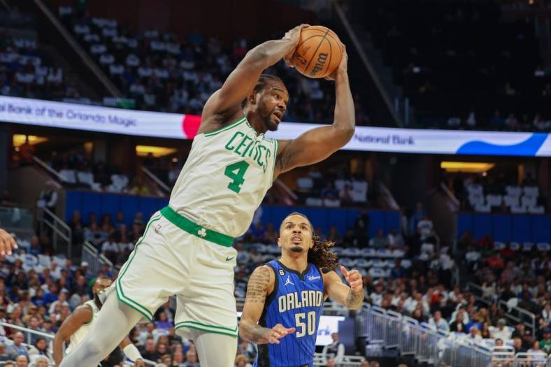 Oct 22, 2022; Orlando, Florida, USA;  Boston Celtics forward Noah Vonleh (4) rebounds the ball against the Orlando Magic in the first quarter at Amway Center. Mandatory Credit: Nathan Ray Seebeck-USA TODAY Sports