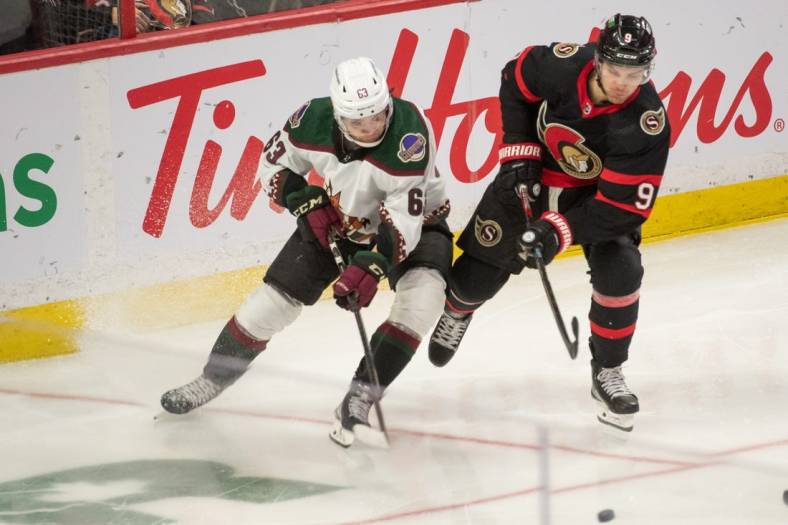 Oct 22, 2022; Ottawa, Ontario, CAN; Arizona Coyotes left wing Mathias Maccelli (63) and Ottawa Senators center Josh Norris (9) play for the puck in the third period at the Canadian Tire Centre. Mandatory Credit: Marc DesRosiers-USA TODAY Sports