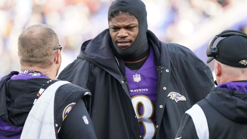 Dec 4, 2022; Baltimore, Maryland, USA; Baltimore Ravens quarterback Lamar Jackson (8) talks with team staff on the sideline in the second quarter after being sacked against the Denver Broncos at M&T Bank Stadium. Mandatory Credit: Mitch Stringer-USA TODAY Sports