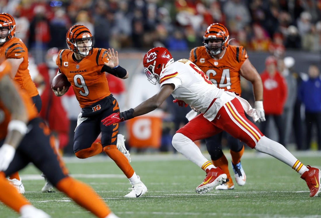 Dec 4, 2022; Cincinnati, Ohio, USA;  Cincinnati Bengals quarterback Joe Burrow (9) runs for the first down as Kansas City Chiefs defensive end Carlos Dunlap (8) makes the tackle during the fourth quarter at Paycor Stadium. Mandatory Credit: Joseph Maiorana-USA TODAY Sports