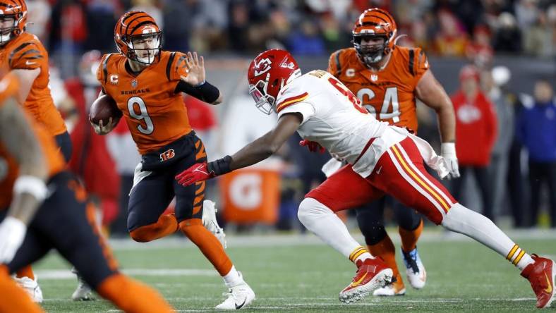 Dec 4, 2022; Cincinnati, Ohio, USA;  Cincinnati Bengals quarterback Joe Burrow (9) runs for the first down as Kansas City Chiefs defensive end Carlos Dunlap (8) makes the tackle during the fourth quarter at Paycor Stadium. Mandatory Credit: Joseph Maiorana-USA TODAY Sports