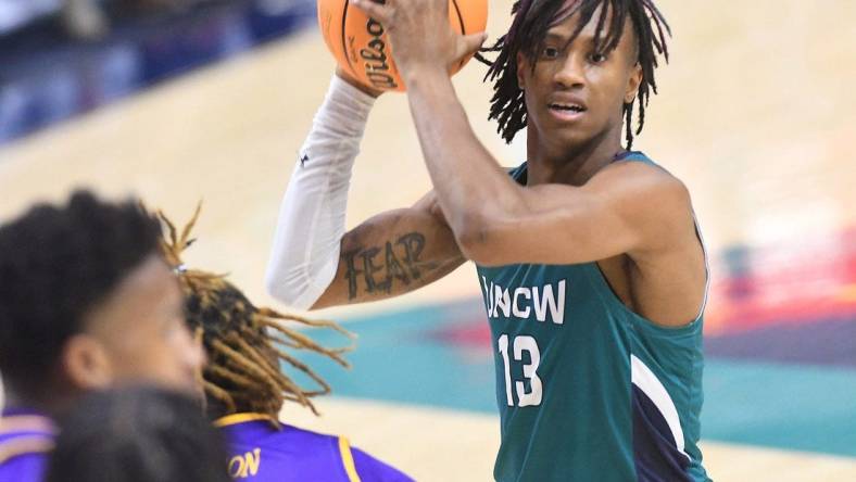 UNCW's #13 Trazarien White passes the ball off as UNCW took on ECU on Tuesday Dec. 6, 2022 at Trask Coliseum in Wilmington, N.C. UNCW beat ECU 74-61.

Wlm Uncw Hoops Vs Ecu19