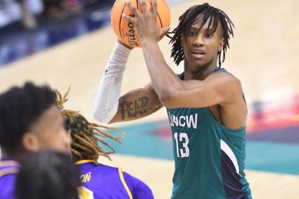 UNCW's #13 Trazarien White passes the ball off as UNCW took on ECU on Tuesday Dec. 6, 2022 at Trask Coliseum in Wilmington, N.C. UNCW beat ECU 74-61.

Wlm Uncw Hoops Vs Ecu19