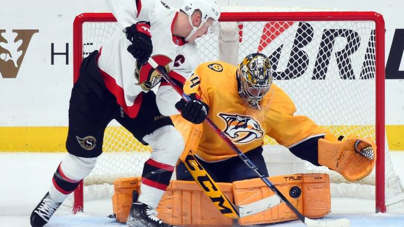 Dec 10, 2022; Nashville, Tennessee, USA; Nashville Predators goaltender Juuse Saros (74) makes a save on a shot by Ottawa Senators left wing Brady Tkachuk (7) during the first period at Bridgestone Arena. Mandatory Credit: Christopher Hanewinckel-USA TODAY Sports