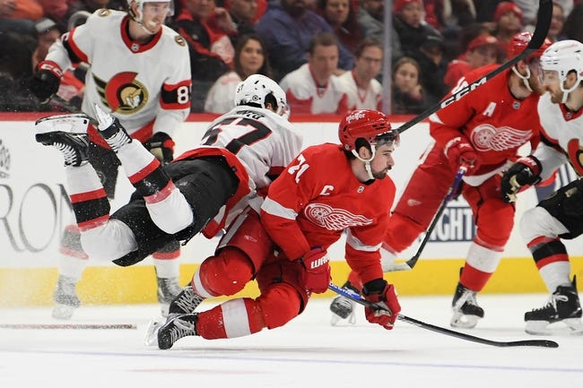 Dec 17, 2022; Detroit, Michigan, USA; Detroit Red Wings center Dylan Larkin (71) and Ottawa Senators center Shane Pinto (57) go airborne after colliding at the blue line  while battling for the puck in the second period at Little Caesars Arena. Mandatory Credit: Lon Horwedel-USA TODAY Sports