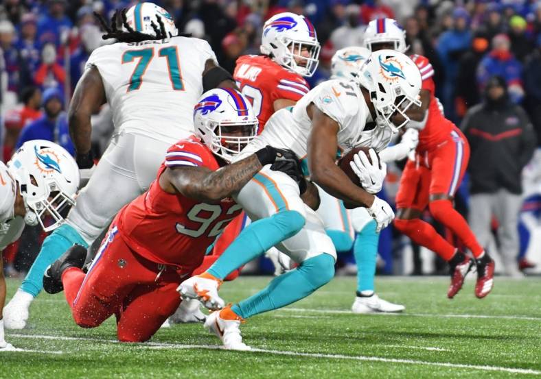 Dec 17, 2022; Orchard Park, New York, USA; Miami Dolphins running back Raheem Mostert (31) is tackled by Buffalo Bills defensive tackle DaQuan Jones (92) in the first quarter at Highmark Stadium. Mandatory Credit: Mark Konezny-USA TODAY Sports