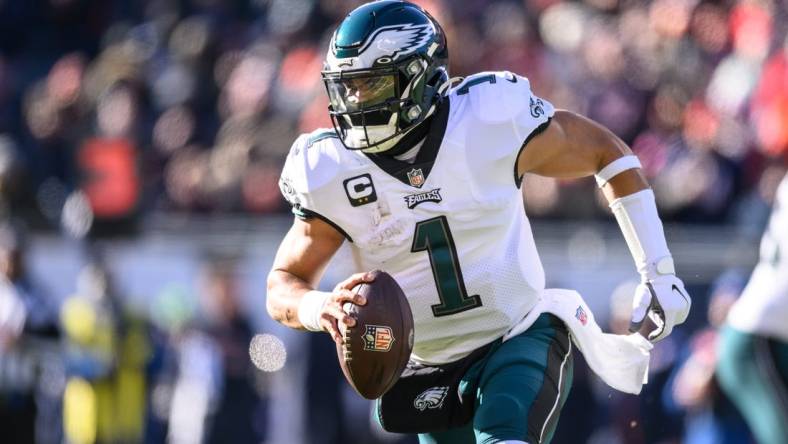 Dec 18, 2022; Chicago, Illinois, USA; Philadelphia Eagles quarterback Jalen Hurts (1) scrambles left looking to throw in the first quarter against the Chicago Bears at Soldier Field. Mandatory Credit: Daniel Bartel-USA TODAY Sports