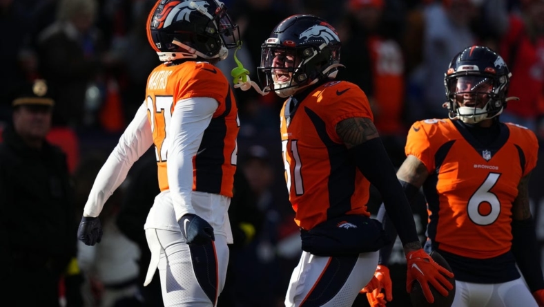 Dec 18, 2022; Denver, Colorado, USA; Denver Broncos safety Justin Simmons (31) celebrates his interception with cornerback Damarri Mathis (27)  in the first quarter against the Arizona Cardinals at Empower Field at Mile High. Mandatory Credit: Ron Chenoy-USA TODAY Sports