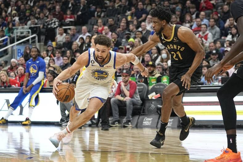 Dec 18, 2022; Toronto, Ontario, CAN;  Golden State Warriors guard Klay Thompson (11) drives to the net against Toronto Raptors forward Thaddeus Young (21) during the first half at Scotiabank Arena. Mandatory Credit: John E. Sokolowski-USA TODAY Sports