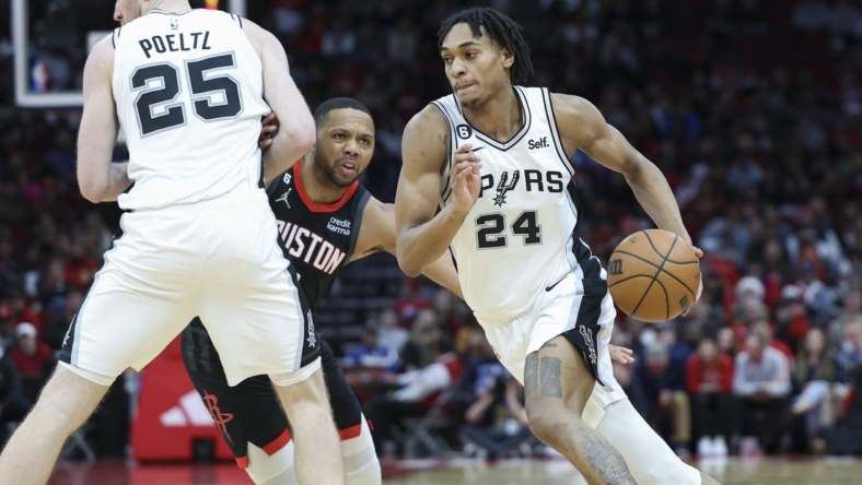 Dec 19, 2022; Houston, Texas, USA; San Antonio Spurs guard Devin Vassell (24) dribbles the ball as Houston Rockets guard Eric Gordon (10) defends during the fourth quarter at Toyota Center. Mandatory Credit: Troy Taormina-USA TODAY Sports