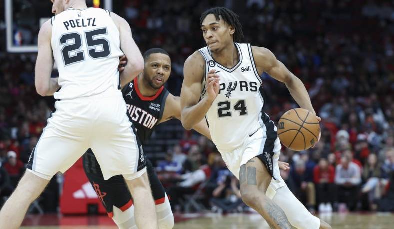 Dec 19, 2022; Houston, Texas, USA; San Antonio Spurs guard Devin Vassell (24) dribbles the ball as Houston Rockets guard Eric Gordon (10) defends during the fourth quarter at Toyota Center. Mandatory Credit: Troy Taormina-USA TODAY Sports