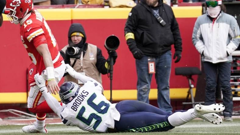 Dec 24, 2022; Kansas City, Missouri, USA; Kansas City Chiefs quarterback Patrick Mahomes (15) scores a touchdown as Seattle Seahawks linebacker Jordyn Brooks (56) makes the tackle during the second half at GEHA Field at Arrowhead Stadium. Mandatory Credit: Denny Medley-USA TODAY Sports