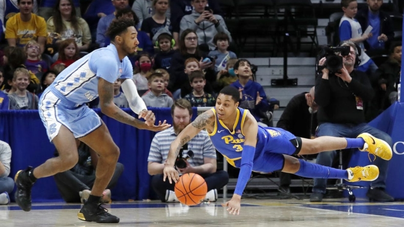 Dec 30, 2022; Pittsburgh, Pennsylvania, USA; North Carolina Tar Heels forward Leaky Black (left) and Pittsburgh Panthers guard Greg Elliott (3) reach for a loose ball during the first half at Petersen Events Center. Mandatory Credit: Charles LeClaire-USA TODAY Sports