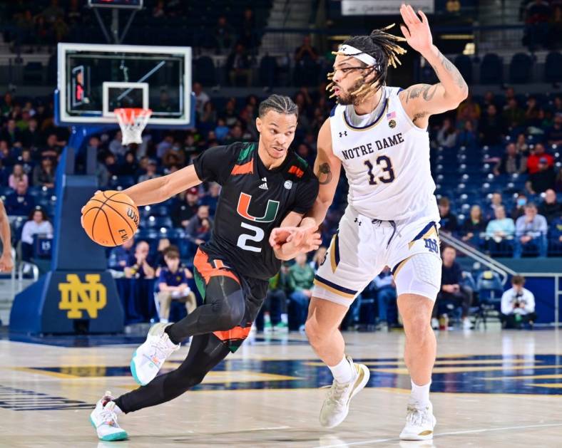 Dec 30, 2022; South Bend, Indiana, USA; Miami Hurricanes guard Isaiah Wong (2) dribbles as Notre Dame Fighting Irish forward Dom Campbell (13) defends in the second half at the Purcell Pavilion. Mandatory Credit: Matt Cashore-USA TODAY Sports