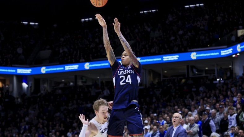 Dec 31, 2022; Cincinnati, Ohio, USA;  Xavier Musketeers guard Adam Kunkel (left) reacts as he fouls Connecticut Huskies guard Jordan Hawkins (24) while he attempts a three-point basket in the second half at the Cintas Center. Mandatory Credit: Aaron Doster-USA TODAY Sports
