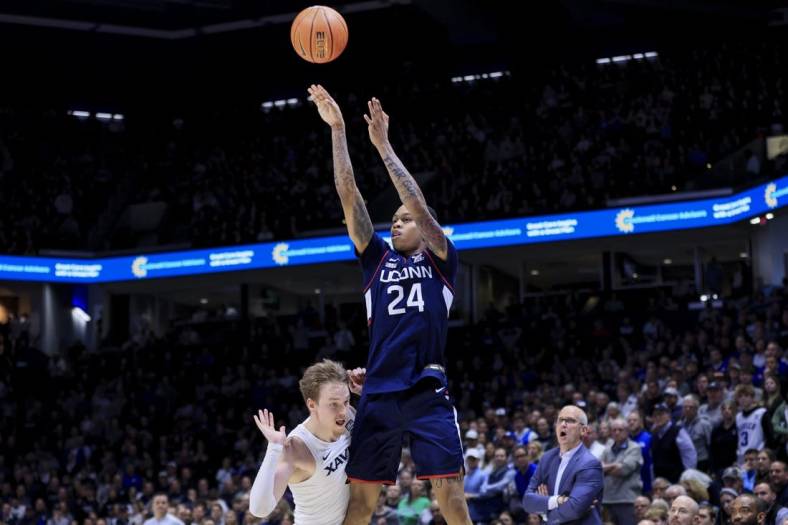 Dec 31, 2022; Cincinnati, Ohio, USA;  Xavier Musketeers guard Adam Kunkel (left) reacts as he fouls Connecticut Huskies guard Jordan Hawkins (24) while he attempts a three-point basket in the second half at the Cintas Center. Mandatory Credit: Aaron Doster-USA TODAY Sports