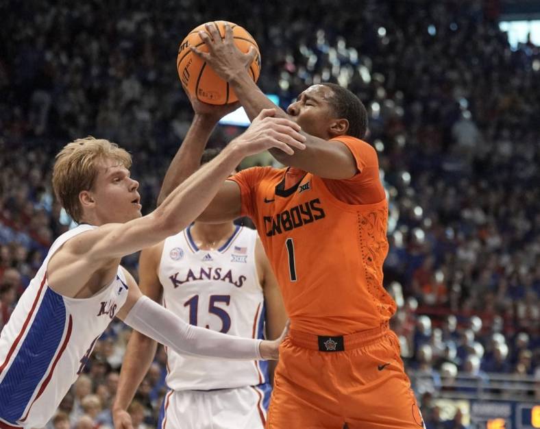 Dec 31, 2022; Lawrence, Kansas, USA; Oklahoma State Cowboys guard Bryce Thompson (1) shoots and is fouled by Kansas Jayhawks guard Gradey Dick (4) during the first half at Allen Fieldhouse. Mandatory Credit: Denny Medley-USA TODAY Sports